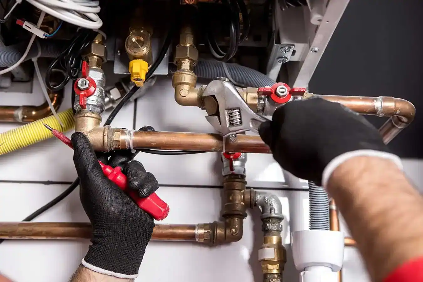Installateur schließt eine neue Gastherme an die Leitungen an