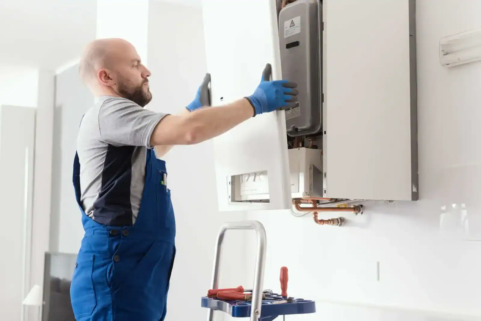 Installateur montiert eine neue Gastherme an der Wand
